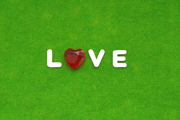 The word love with a heart shape on a green background. Valentine's day.