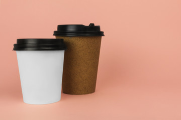 Coffee to go containers with lids on pink background, blank space for logo. Mockup. Copy space.