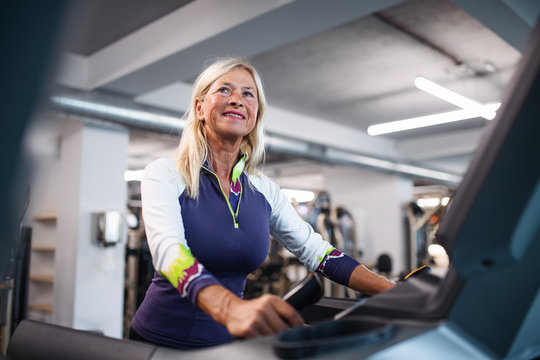 A senior woman in gym doing cardio work out exercise.