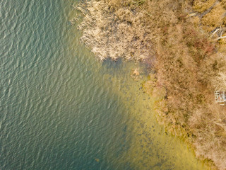 Aerial drone view. Grassy shore of a small island on a river in Kiev in late autumn. Dry grass...