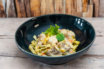 close-up of plate of pasta and chicken with lettuce