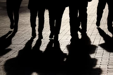 Foto op Aluminium Silhouettes and shadows of people on the street. Crowd walking down on sidewalk, concept of strangers, crime, society, epidemic, population © Oleg