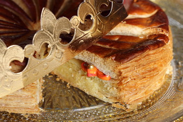 Galette des rois close up. Traditional epiphany's kings galette with one porcelain small charm inside  and a golden paper crown. 
