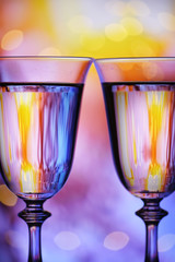 Two glasses of wine on the background of multi-colored lights .. The atmosphere of rest, celebration and relaxation.