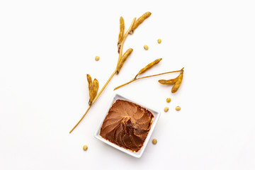 Light brown miso paste isolated on white background. Traditional Japanese seasoning, dry soya beans pods