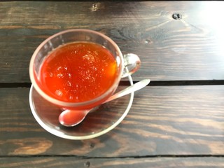 Top view lemon tea that focus the big tree reflex on surface, other part is blurred. The tea glass is on left side of the wooden table then right side free for copy space.