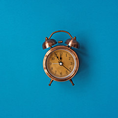 Alarm clock in retro style on a blue background
