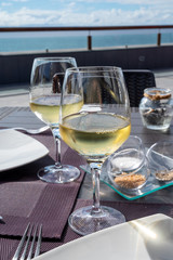 Cold white wine served in restaurant with ocean view
