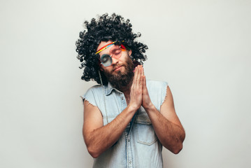 Friendly bearded young male hippie with curly hair in stylish sunglasses isolated on white...