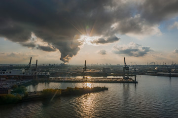 Fototapeta na wymiar Aerial view of sunset over heavy lifting in port of Hamburg HafenCity city during sunset with heavy clouds