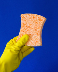 Gloved hand holding orange sponge