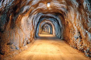 Pedestrian tunnel through the mountains, illuminated, along Adriatic seaside in Montenegro. Inside view.