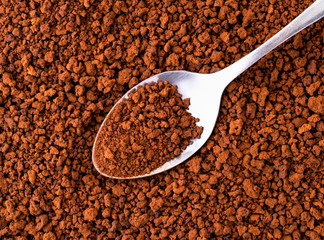 Granular instant coffee with a spoon, background. The view from the top