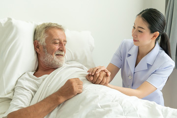 Young nurse take care senior man on a bed, A nurse checking sernior man, Senior man happniess and smiling with nurse, Health care concept