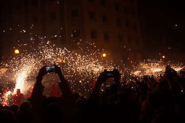 Many people watching and photographing the fireworks parade with their mobiles