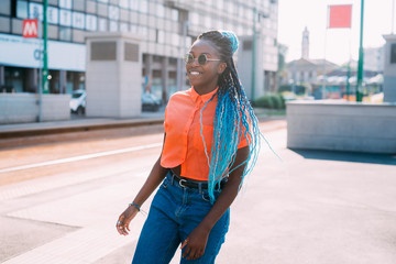 Young beautiful black woman backlight outdoor looking over smiling - confident, attitude, woman power concept