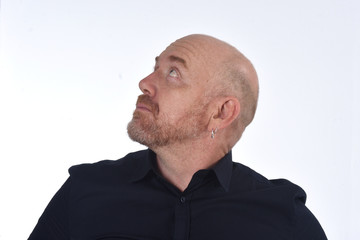 portrait of a bald man looking up on white