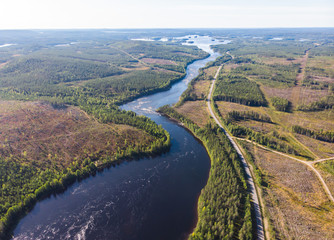 View of Kalix river, Kalixalven, Overkalix locality and the seat in Norrbotten county, Sweden, with forest in sunny summer day, aerial drone view