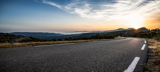 Foto op Canvas Empty long mountain road to the horizon on a sunny summer day at bright sunset © AA+W