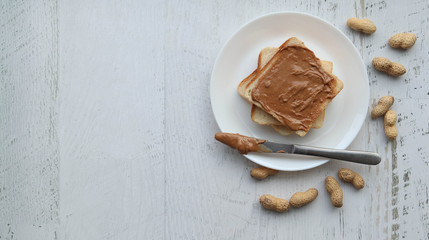 Toast with peanut paste on a white background, flat lay copyspace