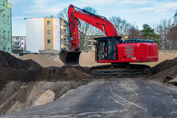 An excavator prepares the foundation of a new building, housing, basement, construction site and an...