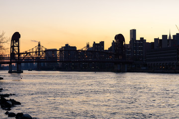 The East River during Sunset with the Roosevelt Island Bridge and Manhattan Skyline in New York City