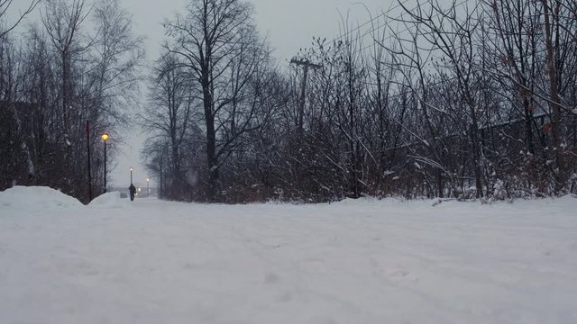 Pedestrian Path during Snow Storm. End of the Day with Street Lamp On. Windy. With People. 4K