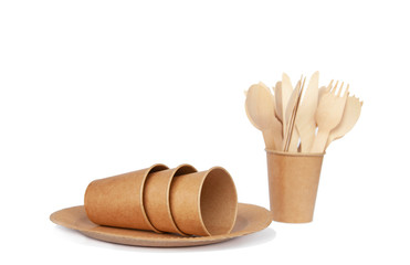 Crockery made from eco kraft paper, paper cups, dishes, bag, fast food containers isolated on white background. Recycling concept. Zero waste. Close-up...