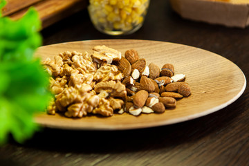 Wooden plate with almonds and walnuts