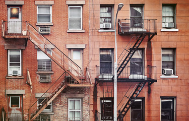 Manhattan old residential buildings with fire escapes, color toning applied, New York City, USA.