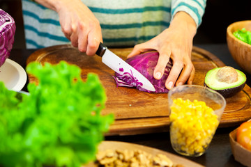 Woman cuts purple cabbage into slices