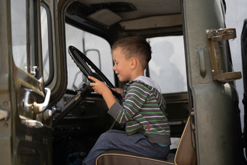 Boy driving in the cab of a truck