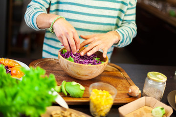 Donna fills a bowl with mixed salad