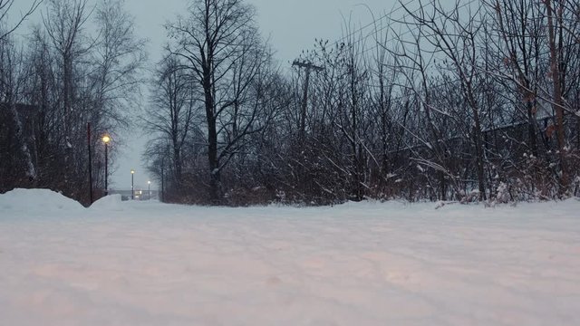 Pedestrian Path during Snow Storm. End of the Day with Street Lamp On. Windy. 4K