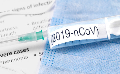 Obraz premium Novel coronavirus (2019-nCoV). Respirator masks, syringe with text (2019-nCoV) on papers background closeup