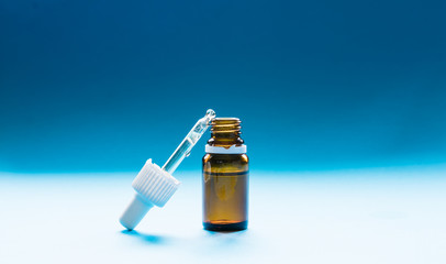 cosmetology, glass bottles with pipettes and cosmetic on a blue background