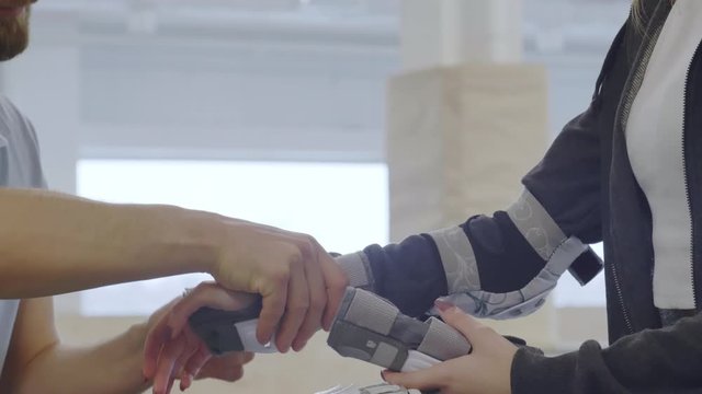Close up of unrecognizable man helping woman putting protecting gear on her hand