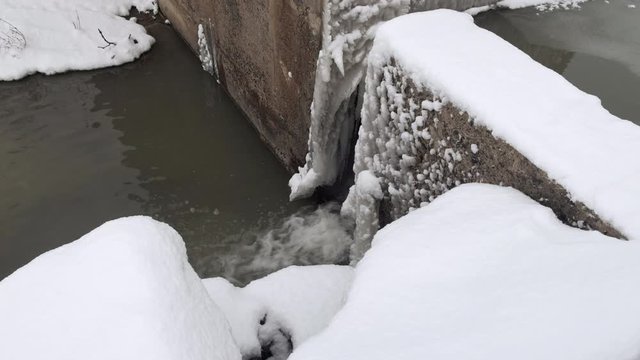 Water Basin in Winter with Snow and Ice.  Pouring Water. Snowing. 4K