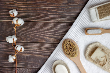Bath and spa accessories with a cotton branch, on a wooden table, top view