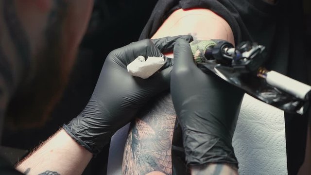 Video of man tattooist getting tattoo of snake for woman