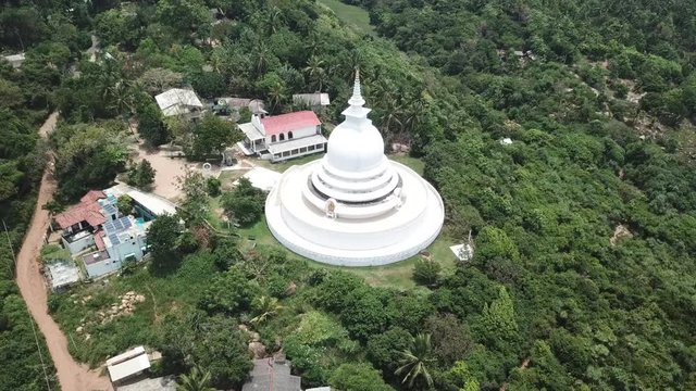 A large white pagoda on top of a mountain. Aerial drone View
