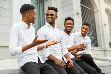 four handsome young african men in white shirts