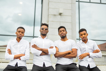 four handsome young african men in white shirts