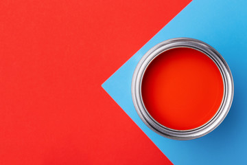 Banner with can of red paint with brush on red and blue background. Top view, minimal styled.