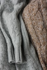 Fototapeta na wymiar Beautiful knitted grey and brown sweaters macro
