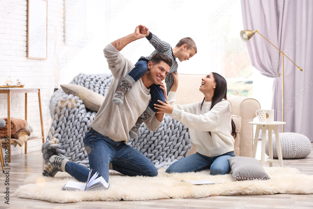 Wall mural Happy family with little son having fun at home. Winter vacation