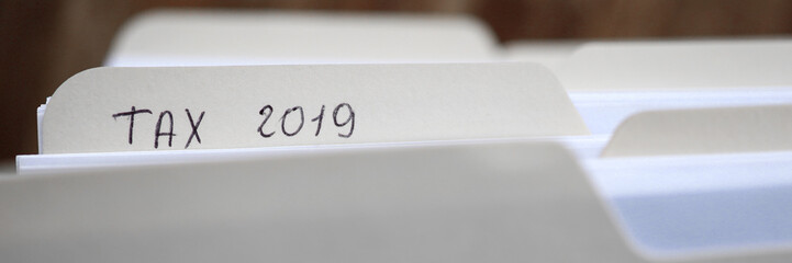 Close-up of important documentation in paper folders with handwriting inscription tax 2019....