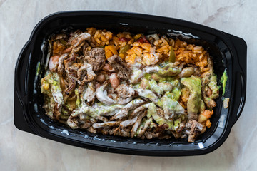 Take Away Mexican Food Carne Asada Steak Fillets, Guacamole Sauce, Pinto Beans and Rice in Plastic Container Box / Package.