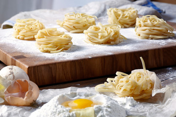 Closeup of homemade noodles on a wooden cutting board.