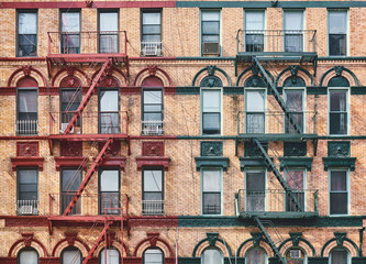 Manhattan old residential building with fire escapes, New York City, USA.